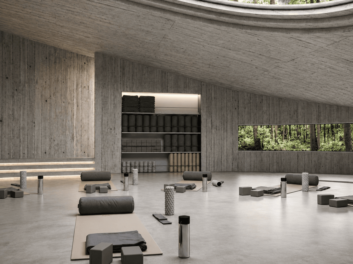 Meditation hall: the oval concrete room lit by a ceiling oculus and a ribbon window to the forest, mats, bolsters and rollers arranged on the floor.