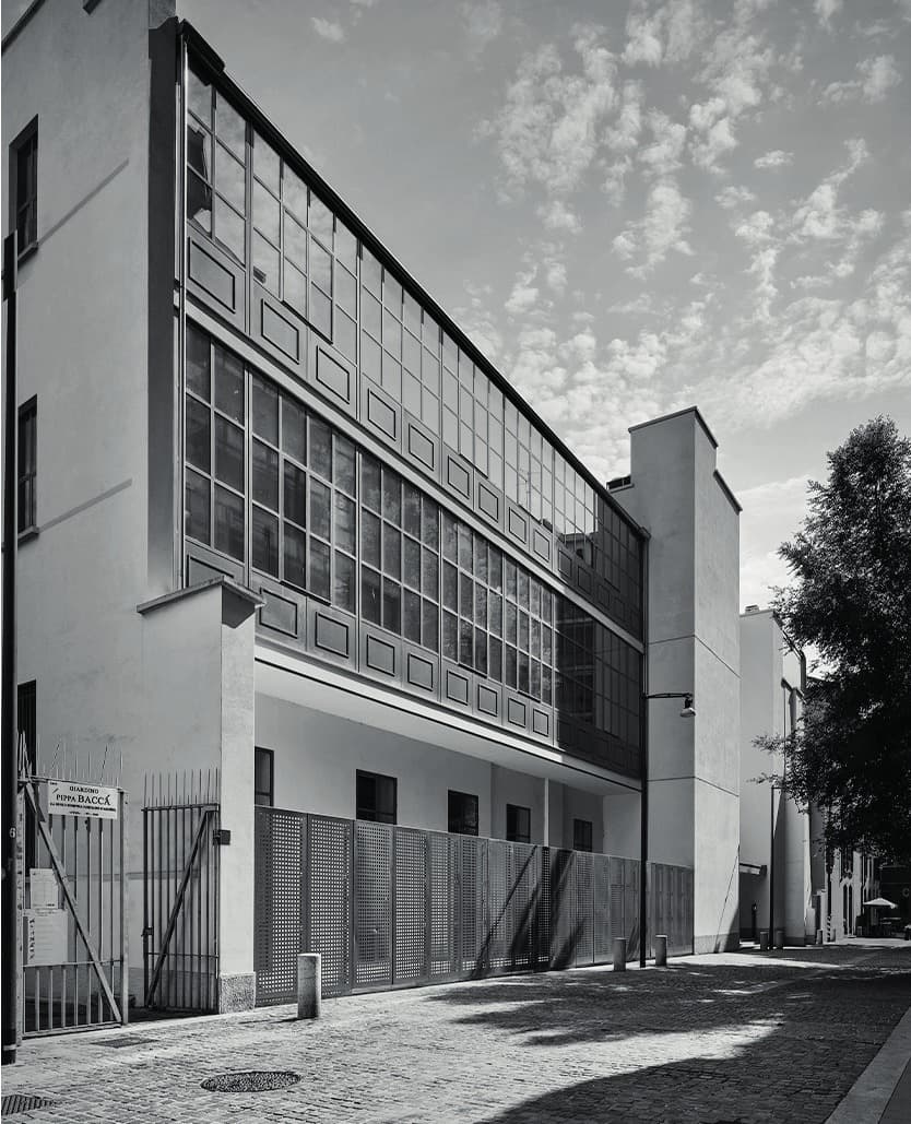 The Casa degli Artisti building seen from the street, its tall studio windows and rendered façade in daylight.