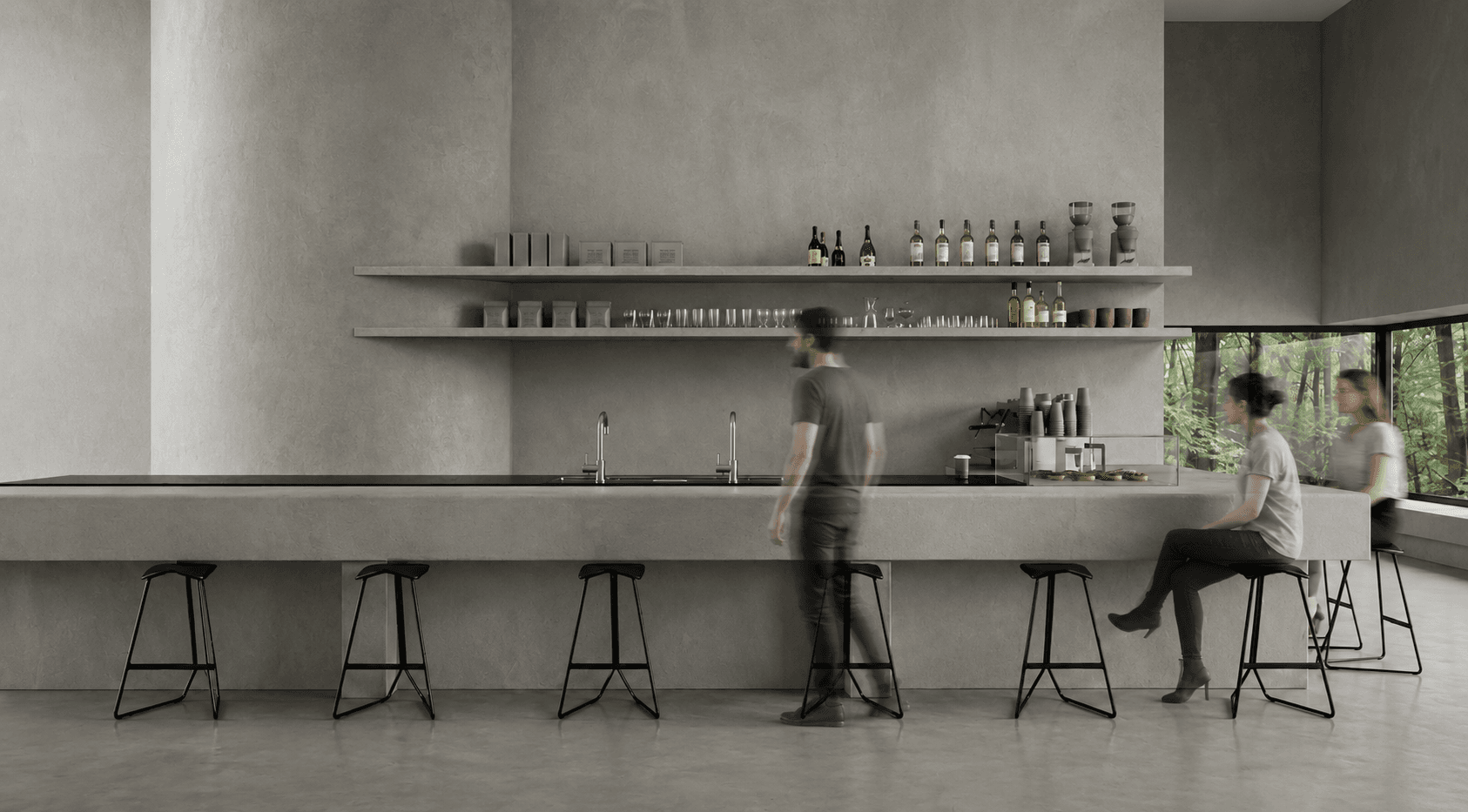 Exhibition bar: a long concrete counter beneath open shelving of bottles and glasses, forest visible through the corner window.