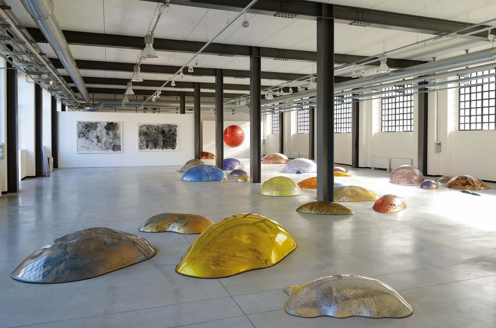 Spazio Messina as found: a tall column-grid hall with a concrete floor and daylight from high windows.